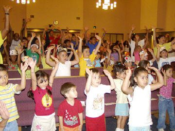 children raising hands at a vacation Bible school